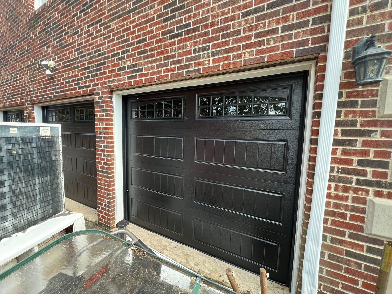 New Door Installation - Dual Black Carriage Doors on Brick Colonial in Hackensack completed in Hackensack, NJ, NJ by Ez2Fix Garage Door Repair